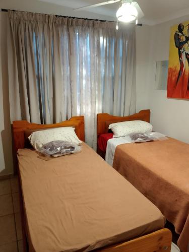 a bedroom with two beds and a window at Lamenatseach 300 in Leeupoort