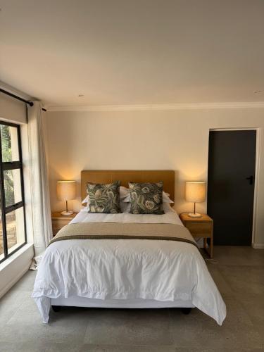 a bedroom with a large white bed with two lamps at First Light Serenity in Hluhluwe