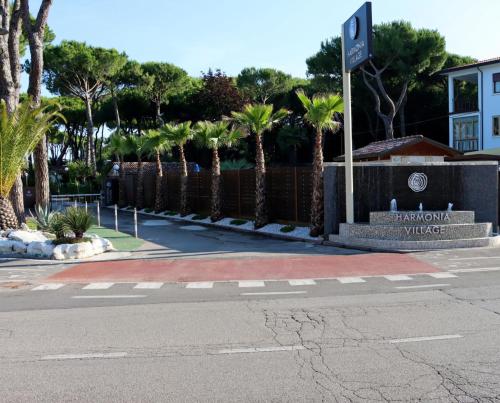an empty street with palm trees in front of a building at Harmonia Village in Lido di Jesolo
