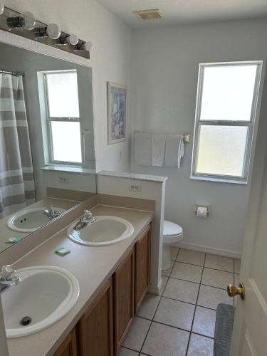 a bathroom with two sinks and a toilet at Villa With Private Pool, and Lake Views in Davenport