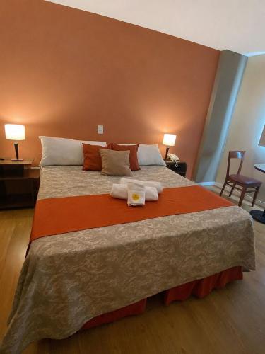 a bedroom with a large bed with two towels on it at Savannah Cordoba Hotel in Córdoba