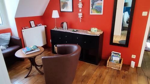 a living room with a chair and a mirror at Ty Maen - Étage avec chambre, coin salon, toilettes et salle de bain in Erdeven