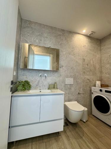 a bathroom with a sink and a washing machine at Ano Syros Orient in Ano Syros