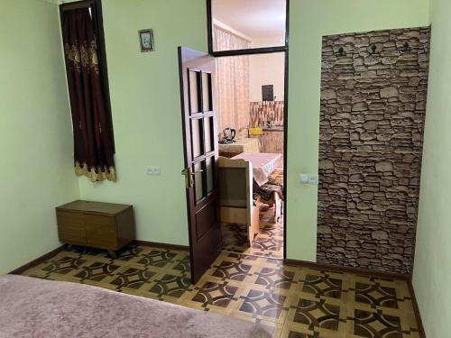 a bedroom with a door and a stone wall at Matevosyans Guest House in Goris