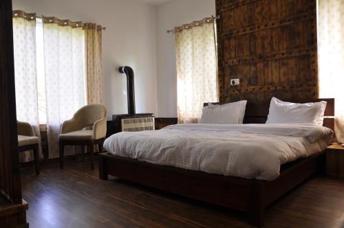 a bedroom with a large bed with a wooden headboard at VELORA-DOODHPATHRi in Aphit