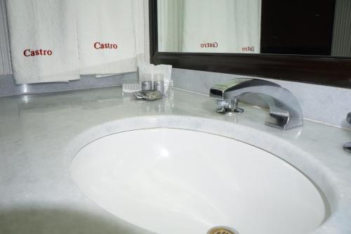 a white sink in a bathroom with a mirror at Hotel Castro in Mexico City