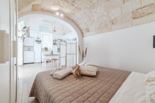 a bedroom with a large bed in a white room at A L Tourist House - La Corte di Cavuor in Monopoli