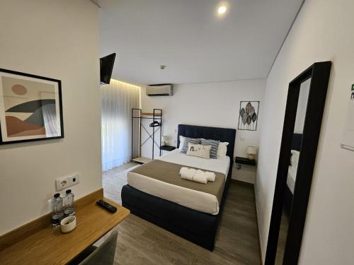 a hotel room with a bed and a mirror at DiROMANE in Braga