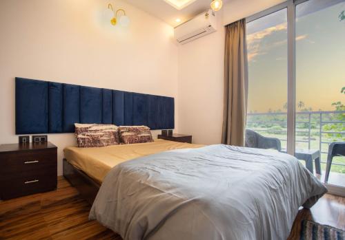 a bedroom with a large bed and a large window at Luxury Apartment With Farm View in Siolim