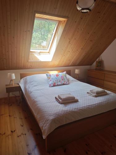 a bedroom with a bed with two towels on it at Wiesiówka nad Wkrą in Goławice