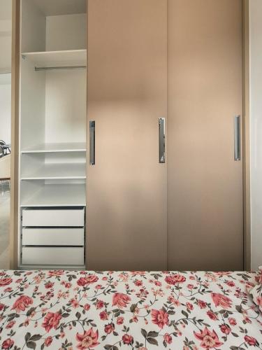 a bedroom with a bed with a floral bedspread at Bela Vista Por do Sol in Espirito Santo Do Pinhal
