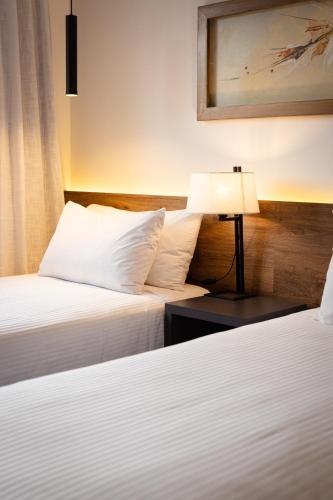 a hotel room with two beds and a lamp at Dazzler by Wyndham Salta in Salta