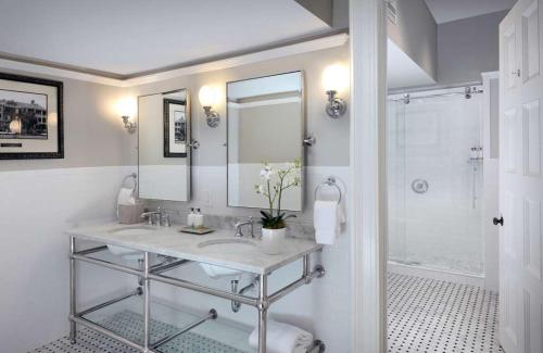 a bathroom with a sink and a mirror and a shower at Jekyll Island Club Resort in Jekyll Island