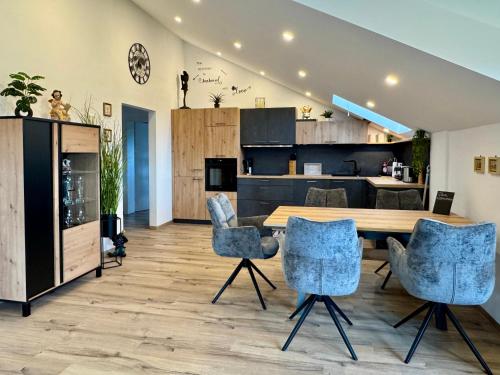a kitchen and living room with a wooden table and chairs at LuxLife - Panorama Bergblick, Sauna, Balkon, Luxus Pur in Buchenberg