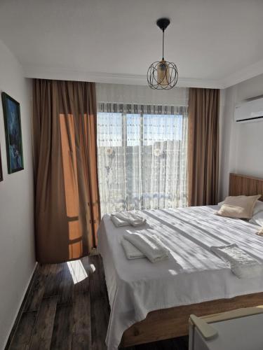 a bedroom with a large bed and a window at CARETTA PANSİYOn in Kaş