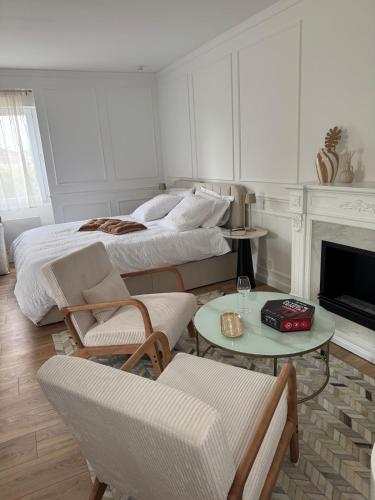 a living room with two beds and a fireplace at La Folie Blanche in Vertou