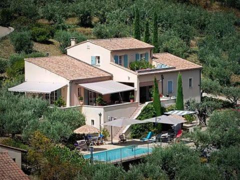 a large house with a swimming pool in front of it at Le mas christiane in Buis-les-Baronnies