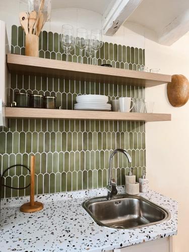 a kitchen counter with a sink and green tiles at Tu mejor estadia en Tarragona centro in Tarragona