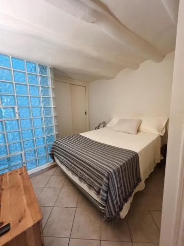 a bed in a room with a large window at Tu mejor estadia en Tarragona centro in Tarragona