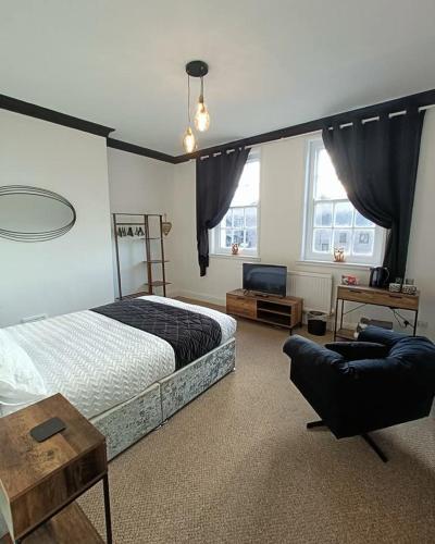 a bedroom with a bed and a couch and a tv at Edinburgh Arms in York