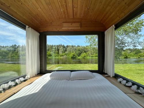 a large window in a bedroom with a large bed at Citi Krasti Eco Spa Residence in Kārļzemnieki