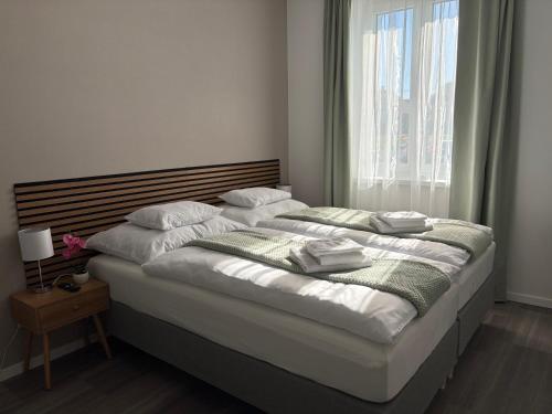 a large bed in a bedroom with a window at PlatanHome 12 in Lenti