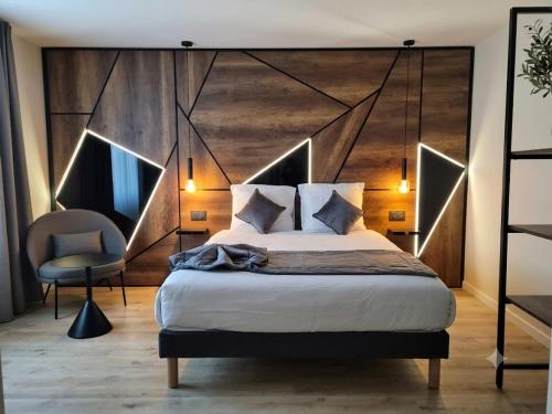 a bedroom with a large bed with a large wooden headboard at APARTÉ HOTEL Dijon Sud in Chenôve