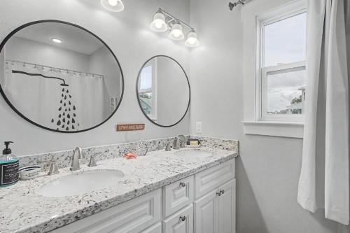 a bathroom with two sinks and two mirrors at 3BD Beach House by Next Step Property Management in Long Beach