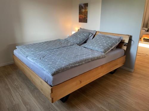 a bed with a blue comforter and two pillows at Ferienhaus am Hennesee in Meschede