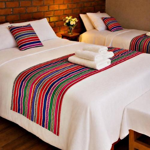 two beds with towels sitting on top of them at Fundo Alma Andina in Jauja