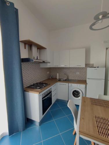 a kitchen with a blue tile floor and white cabinets at L'Eco del Mare in Pisciotta
