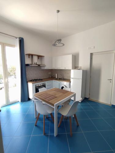 a kitchen with a wooden table and two chairs at L'Eco del Mare in Pisciotta
