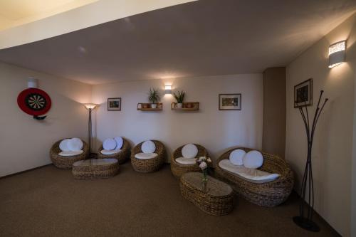 a room with four wicker chairs in a room at Hotel Churáňov in Stachy