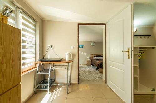 a hallway with a table and a door to a room at Willa Tina in Karwia