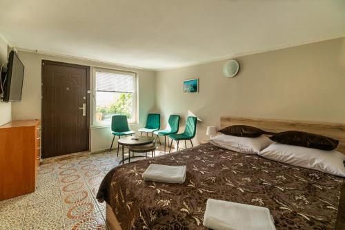a bedroom with a bed and chairs and a window at Willa Tina in Karwia