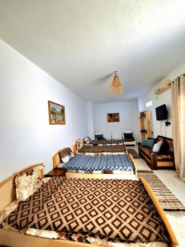 a bedroom with two beds and a couch at Dar Aziz in Sousse