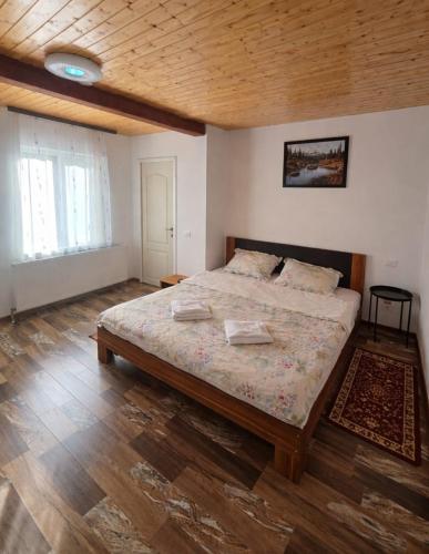 a bedroom with a large bed and a wooden ceiling at La Stermin in Viştea de Sus