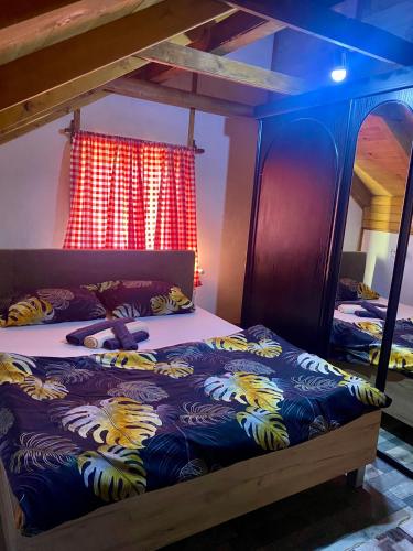 a bedroom with two bunk beds and a red curtain at Vikendica Stanković in Šipovo