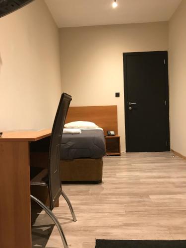 a bedroom with a bed and a desk with a chair at Royal Hotel in Brussels