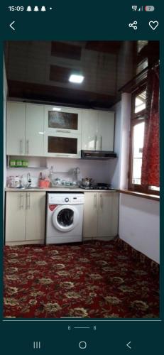 a kitchen with white cabinets and a washing machine at 2-kichik daha in Andizhan