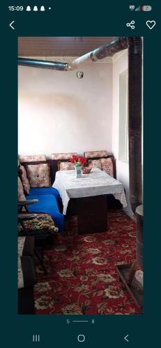 a living room with a table and a couch at 2-kichik daha in Andizhan