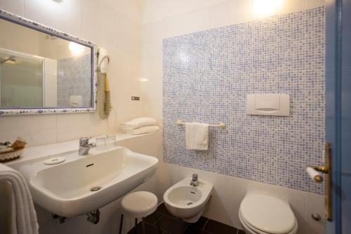 a white bathroom with a sink and a toilet at B&B Villa Clodia in Saturnia