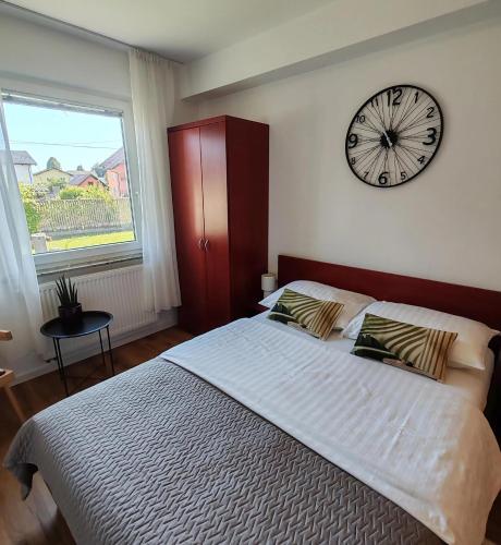 a bedroom with a large bed with a clock on the wall at Lucky center Ljubljana in Ljubljana