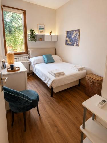 a bedroom with a bed and a chair and a window at Casa Camelia Mare in Viareggio