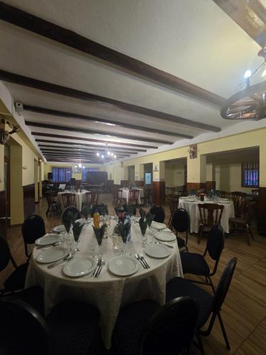 a dining room with a table with plates and silverware at La Stermin in Viştea de Sus