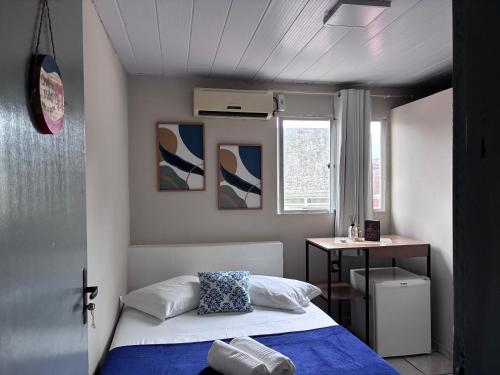 a small bedroom with a bed and a desk at Pousada Vilas do Frances Beira Mar in Praia do Frances