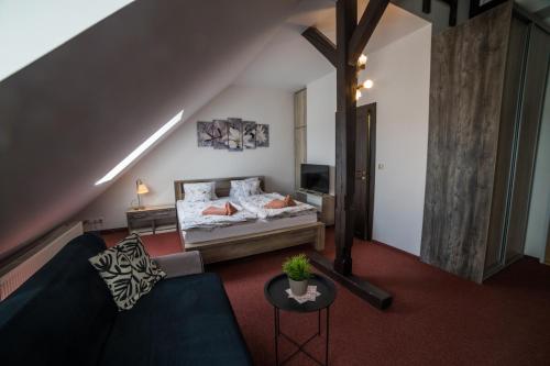a living room with a bed and a couch at Hotel Churáňov in Stachy