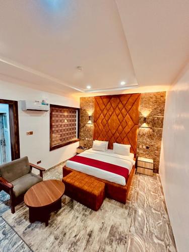 a bedroom with a bed and a couch and a table at Lexworld Hotels in Aba