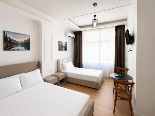 a hotel room with two beds and a table at Hotel Danja in Laç