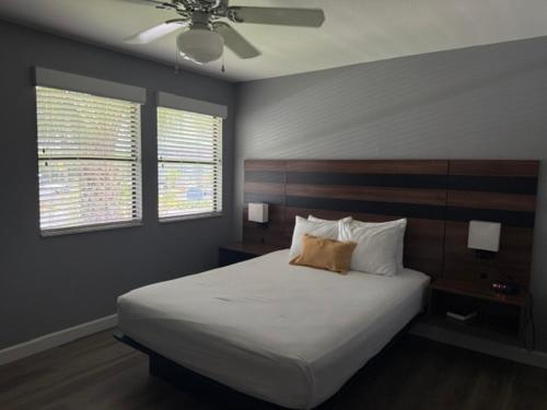 a bedroom with a large bed and two windows at Villas at Fortune Place in Kissimmee